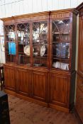 Large yew wood finish breakfront bookcase having four glazed doors above four cupboard doors on