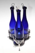 Three 18th Century Bristol Blue glass bottles in silver plate stand, 34cm.