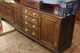 Large oak dresser base having four central drawers flanked by cupboard, 171cm by 53cm.