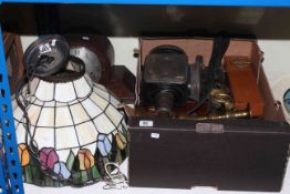 Box of metalwares, glass Tiffany style light shade, horsebrasses, leathers, coach lamp,