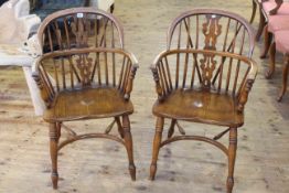 Pair of Windsor elm pierced splat back elbow chairs with crinoline stretchers.