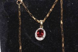 9 carat gold, garnet and diamond pendant with chain, boxed.
