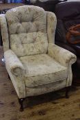 Wing back armchair in floral and beige ground fabric.