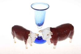 Two Beswick cows and a blue glass vase.