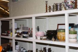 Shelf of ceramics, glass, planters, prints and brass.