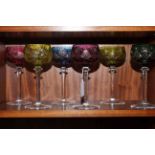 A set of six crystal hock glasses with different coloured bowls.