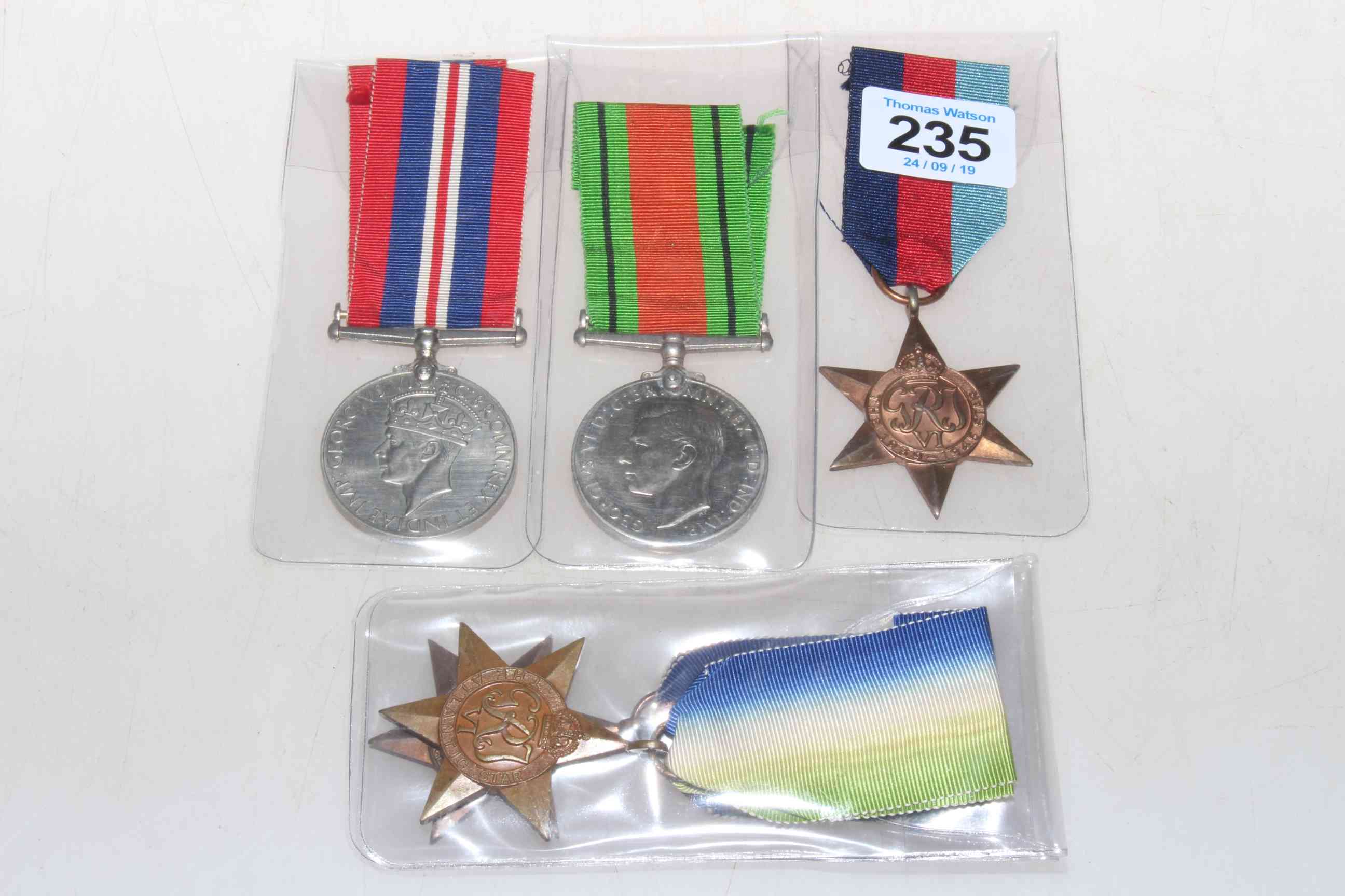Four WWII medals with ribbons.