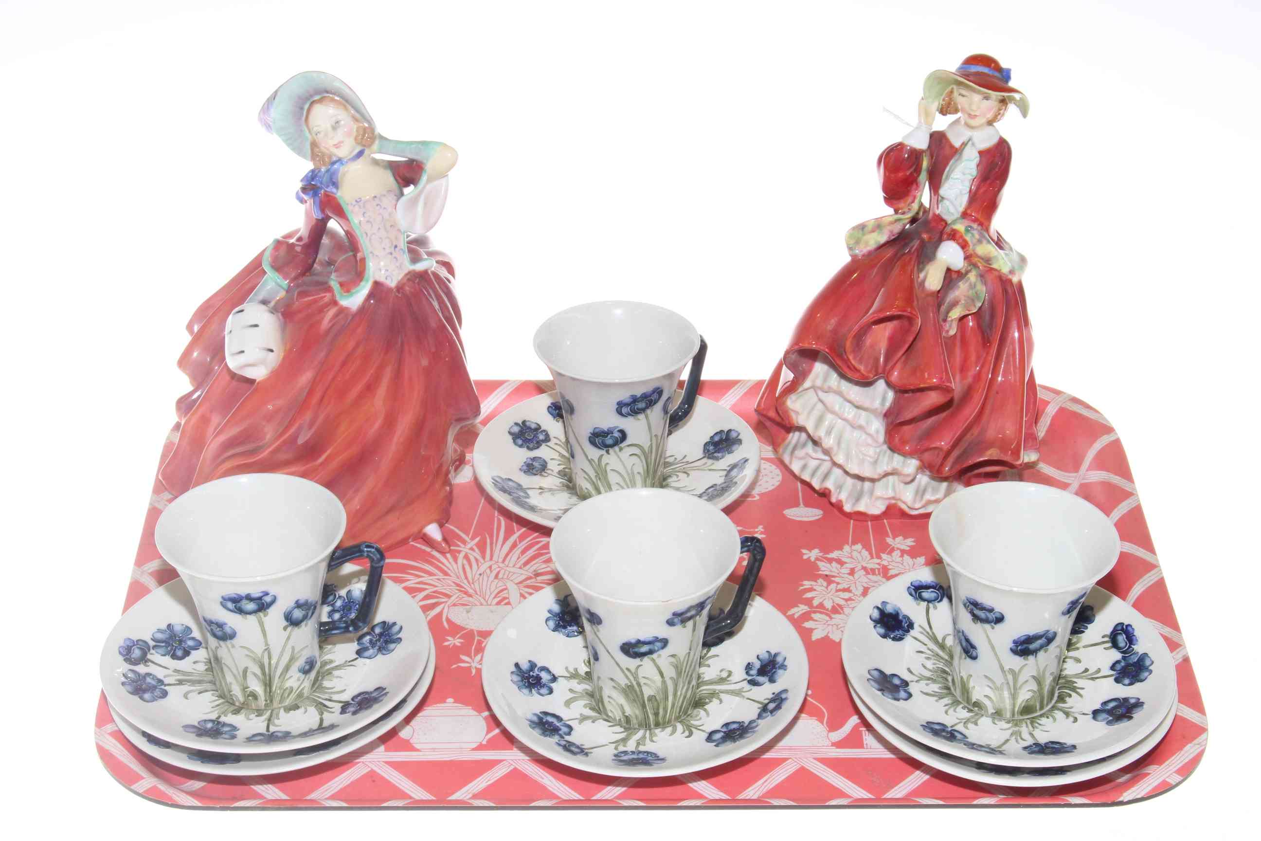 Macintyre four cups and six saucers, and two Royal Doulton figures.