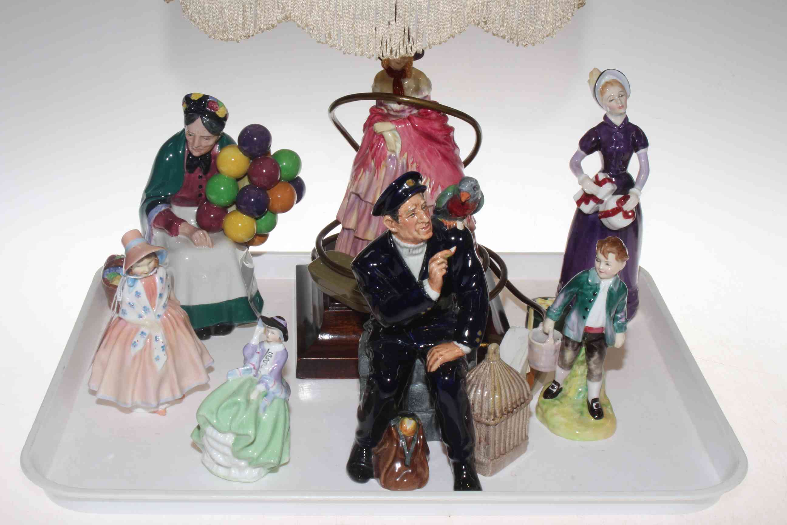 Collection of seven Royal Doulton figures and table lamp with shade.