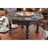 Continental carved circular low table with central inset copper bowl, 43cm by 77cm diameter.