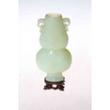 Chinese pale green jade two handle vase, 16.5cm, with wood stand.