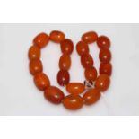 Necklace of twenty large amber beads, 99 grams.