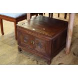 Chinese style low centre storage table with two carved panel doors, 46cm by 61cm.