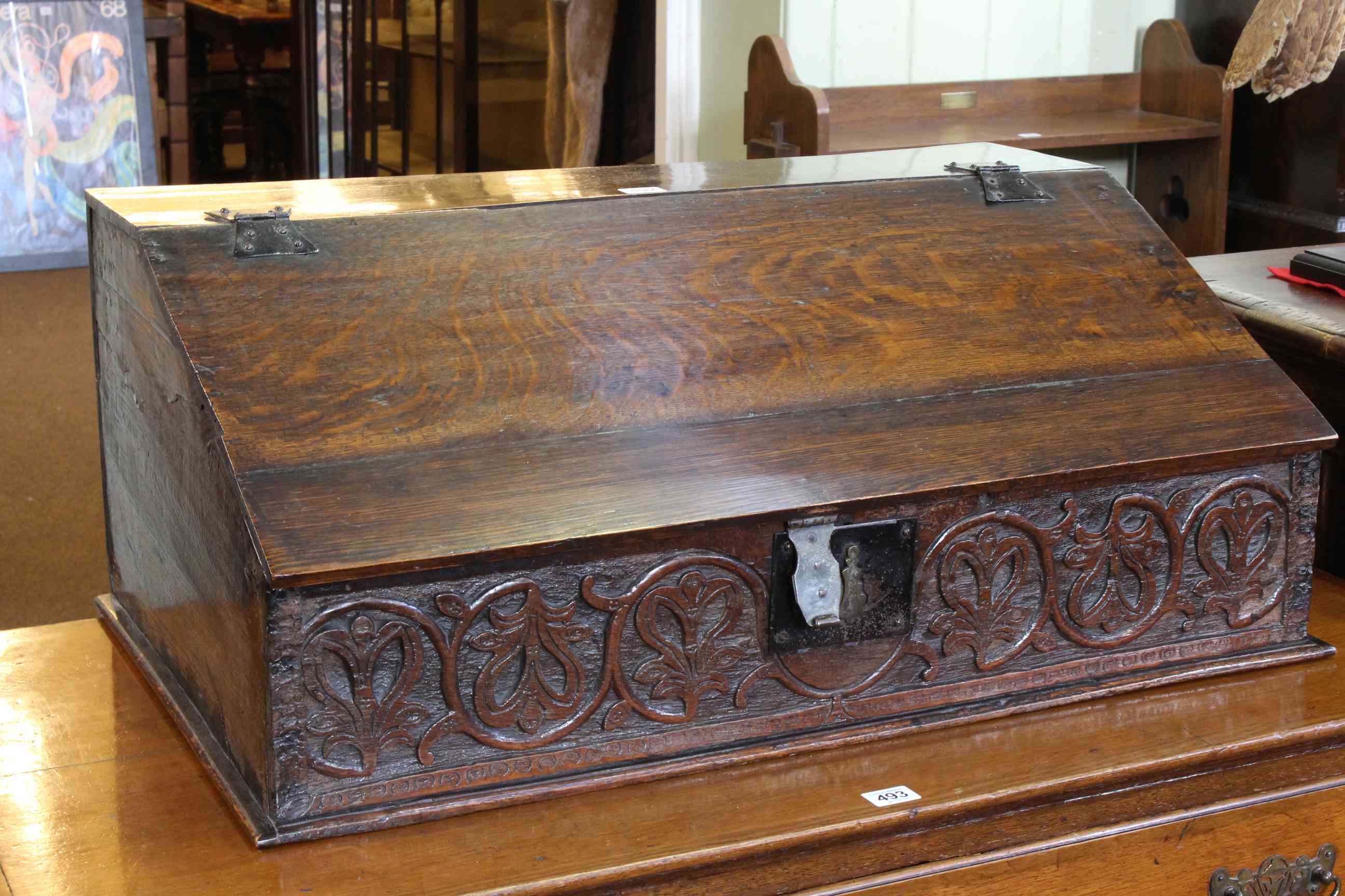 Antique carved oak slope front bible box, the lid enclosing three drawers, 31.5cm by 76.5cm.