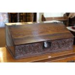 Antique carved oak slope front bible box, the lid enclosing three drawers, 31.5cm by 76.5cm.