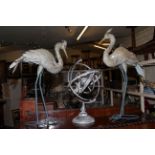 Pair of metal garden storks and metal armillary sphere.