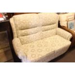 Two seater settee in light foliate pattern fabric.