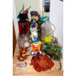Collection of glass and paperweights including clowns, ruby glass, lidded jar.