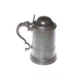 Antique pewter lidded tankard with scroll handle and shaped thumb-piece.