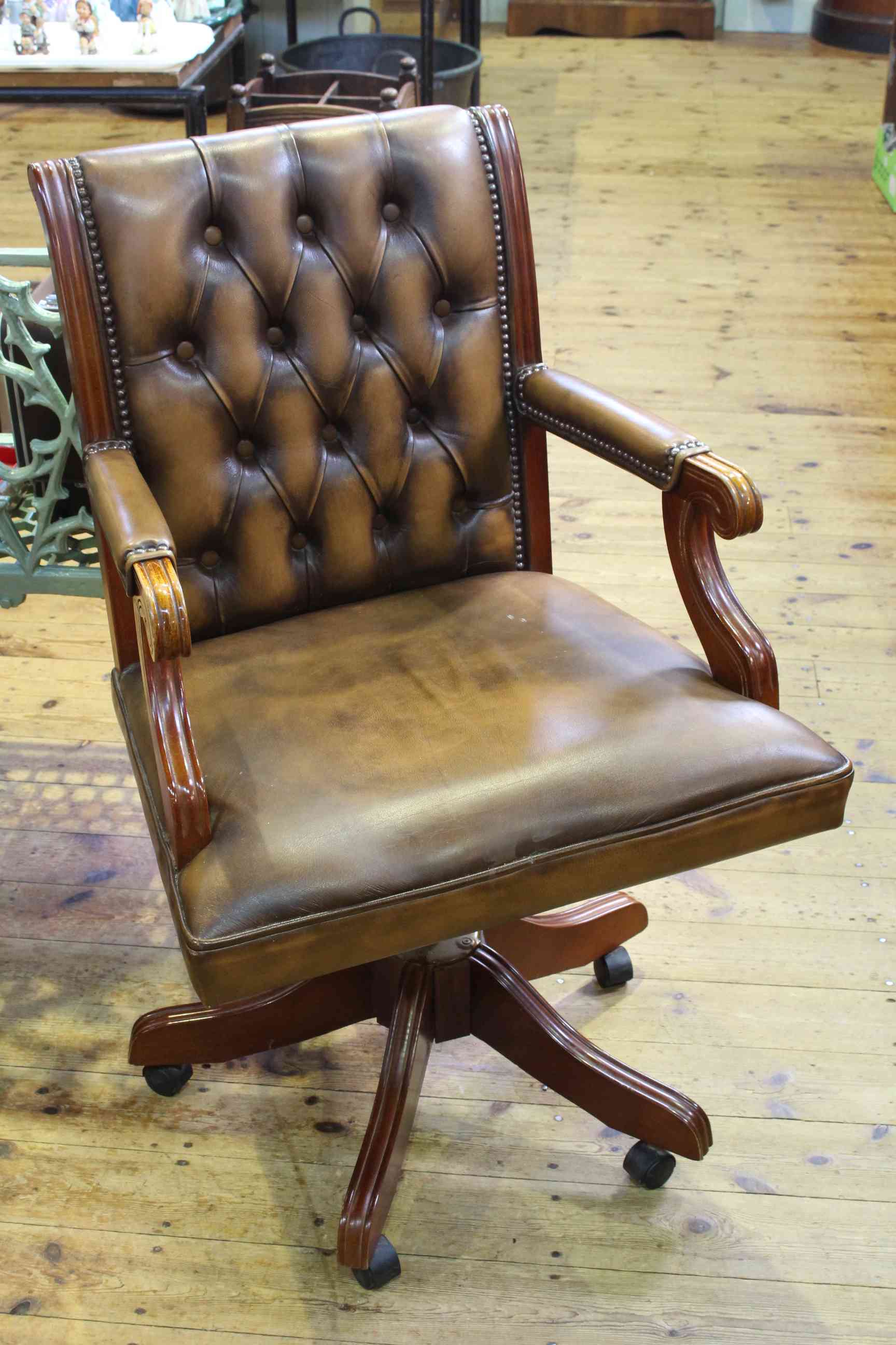 Brown buttoned leather swivel desk chair.