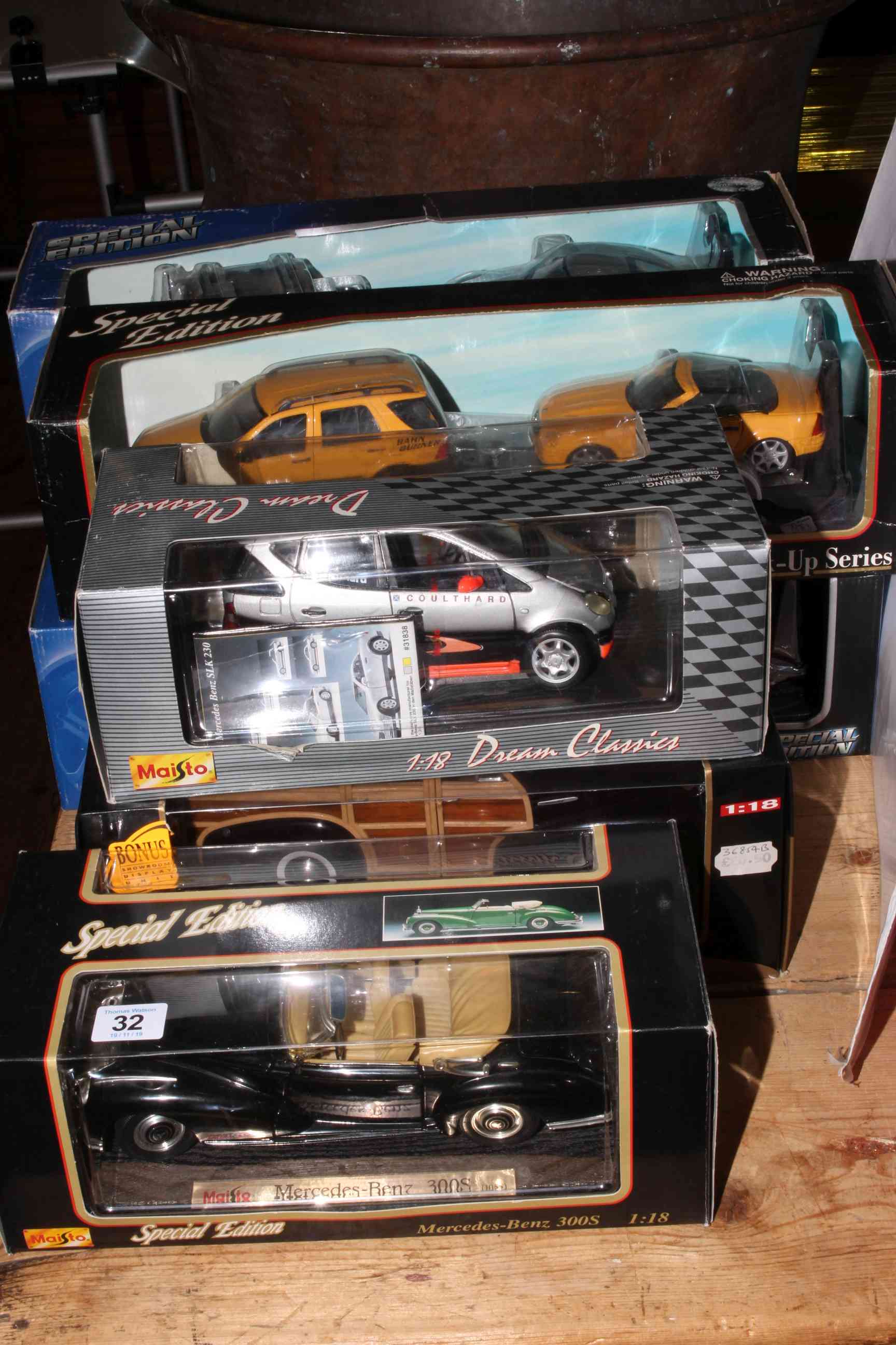 Collection of Maisto Diecast model cars in boxes.