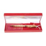 Les Must de CARTIER gold plated biro pen with ornate foliate barrel, boxed.