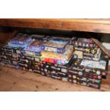 Large assortment of jigsaw puzzles.