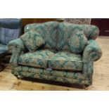 Two seater settee with loose cushions in green and gilt foliate with rope piping.