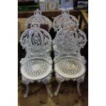 Set of four cast metal garden chairs.