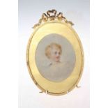 Oval gilt easel frame with ribbon pediment and cherub painting.