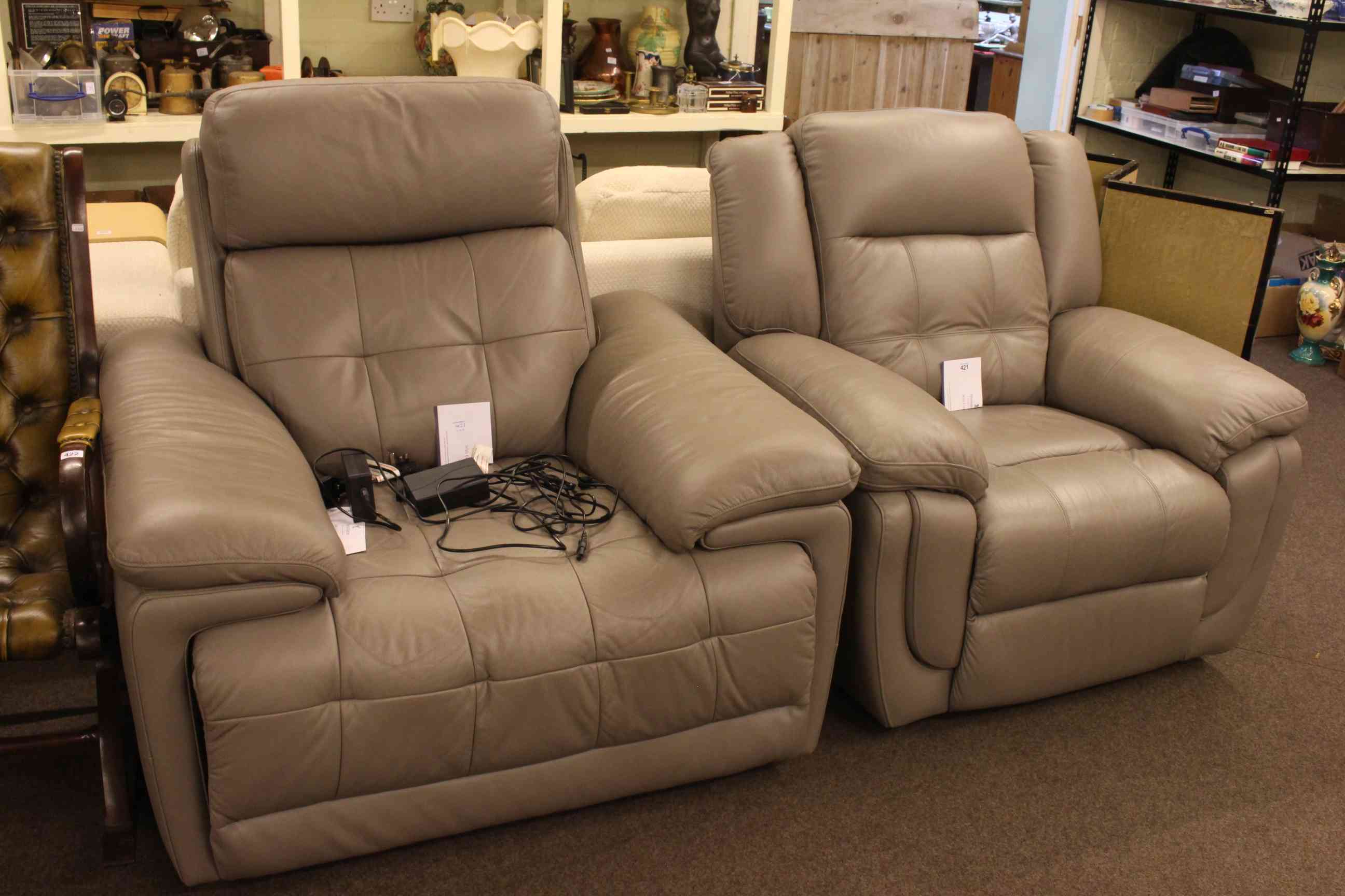 Pair of grey leather La-z-boy electric reclining armchairs, one of which also rocks and swivels.