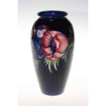 Moorcroft pottery Anemone vase with dark blue ground, bearing warrant label, 25cm.