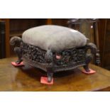 Ornate carved hardwood footstool with serpentine sided with upholstered top.