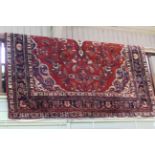 Persian red ground rug with floral design, 300cm by 210cm.
