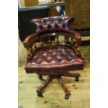 Deep buttoned red leather captains chair.