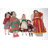 Collection of five vintage costume dolls including bisque head and Japanese fabric.