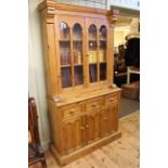 Pine cabinet bookcase having two glazed panel doors above three drawers with three cupboard doors