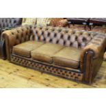 Tan deep buttoned leather three seater Chesterfield settee.