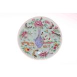 Chinese plate decorated with centre vase and butterflies and flowers on celadon green ground.