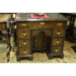 Antique walnut crossbanded kneehole desk having long frieze drawer above an inset central cupboard