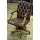 Brown deep buttoned leather swivel desk chair.