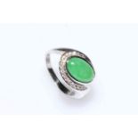 18 carat white gold oval jade stone and diamond twist set cluster ring, size N.