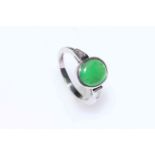 Circular jade stone ring with diamond set shoulders in 18 carat white gold, size N.