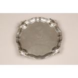 George II silver card tray, pie crust edge with acanthus leaves raised on four scroll feet, assay