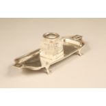 Edwardian silver pen tray with a cut glass ink well with a silver hinged cover, raised on paw