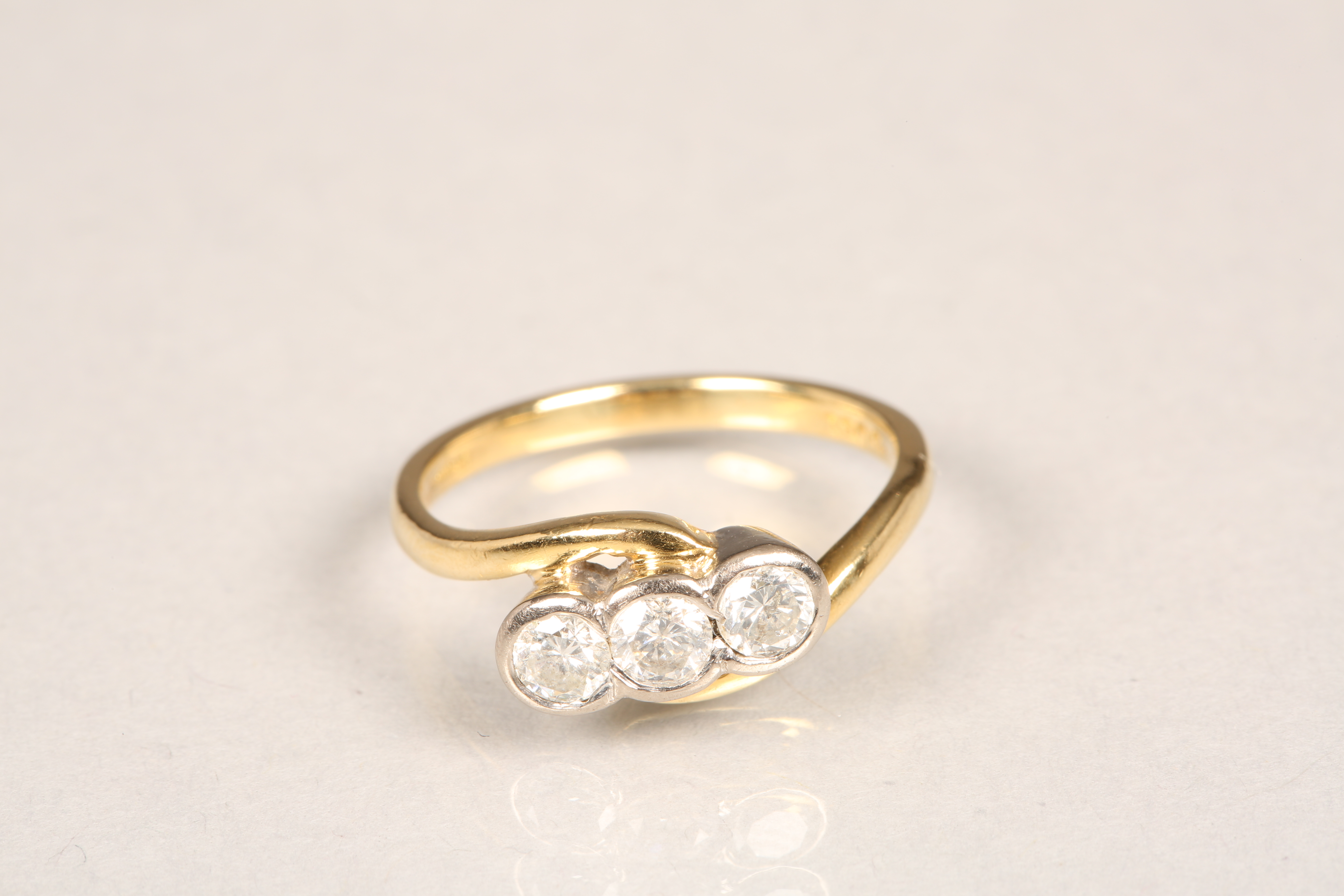 18 carat gold three stone diamond twist ring. Three brilliant cut 0.2 carat diamonds. Ring size N
