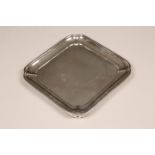 Victorian silver salver of square form, pie crust edge raised on four ogee feet, assay marked