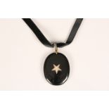Victorian enamel and diamond mourning pendant. Oval black enamel pendant set to centre with 11 old