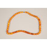 String of butterscotch amber beads. 64cm long, largest bead 20mm diameter