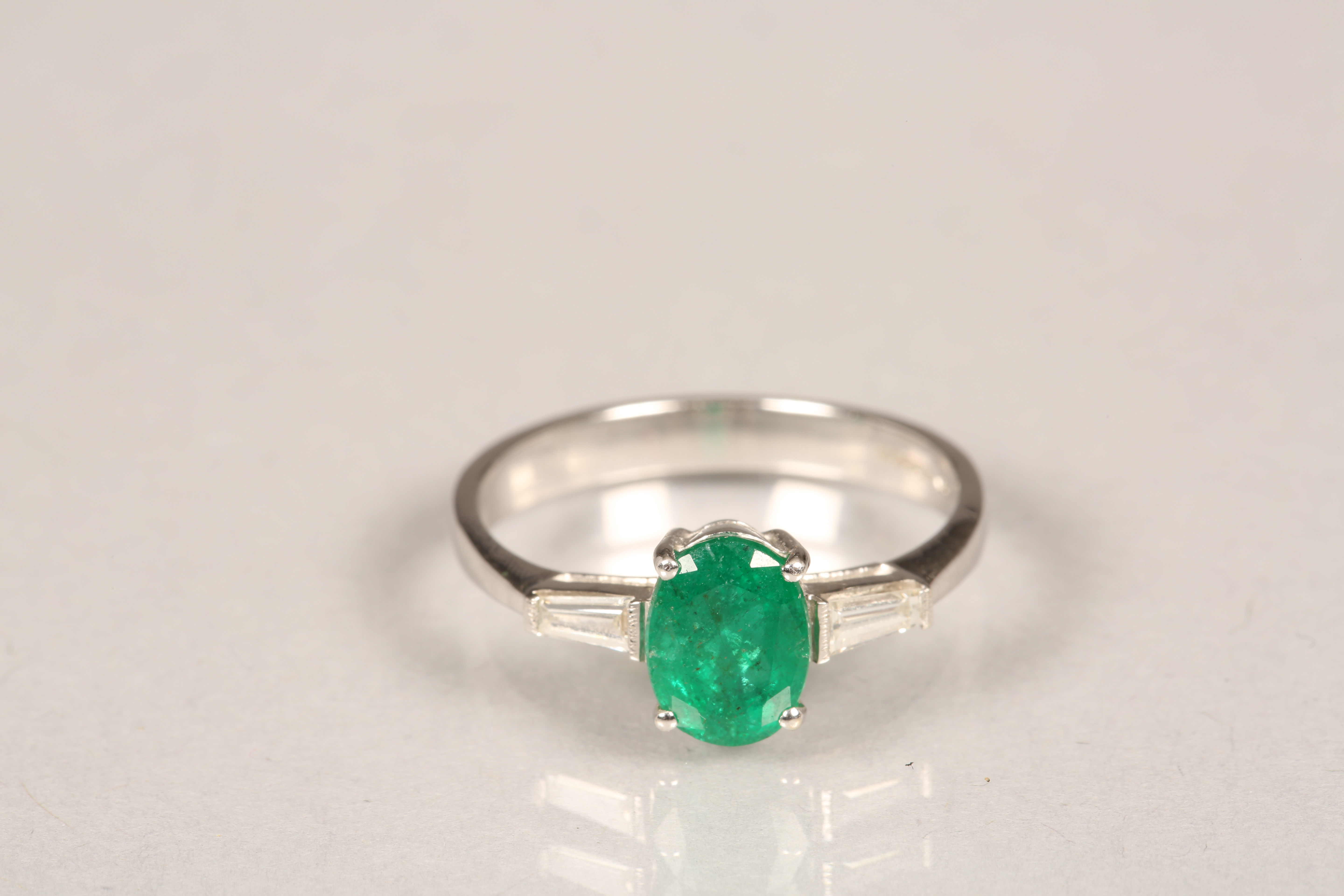 Ladies 18 carat white gold emerald and diamond ring, central emerald flanked by a baguette cut